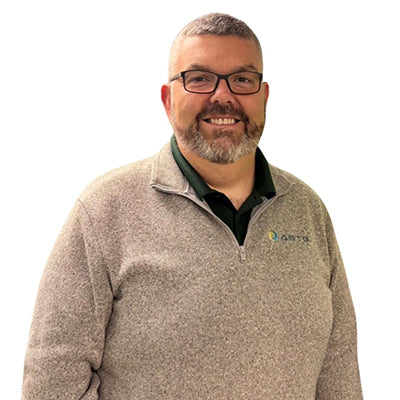 Kevin Ramazn wearin a beige sweater with the ASTG logo on a white background